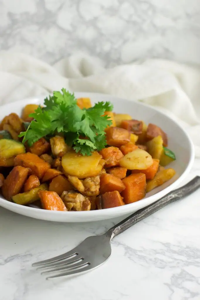 Sweet Potato and Pineapple Stir-Fry in white bowl with fork