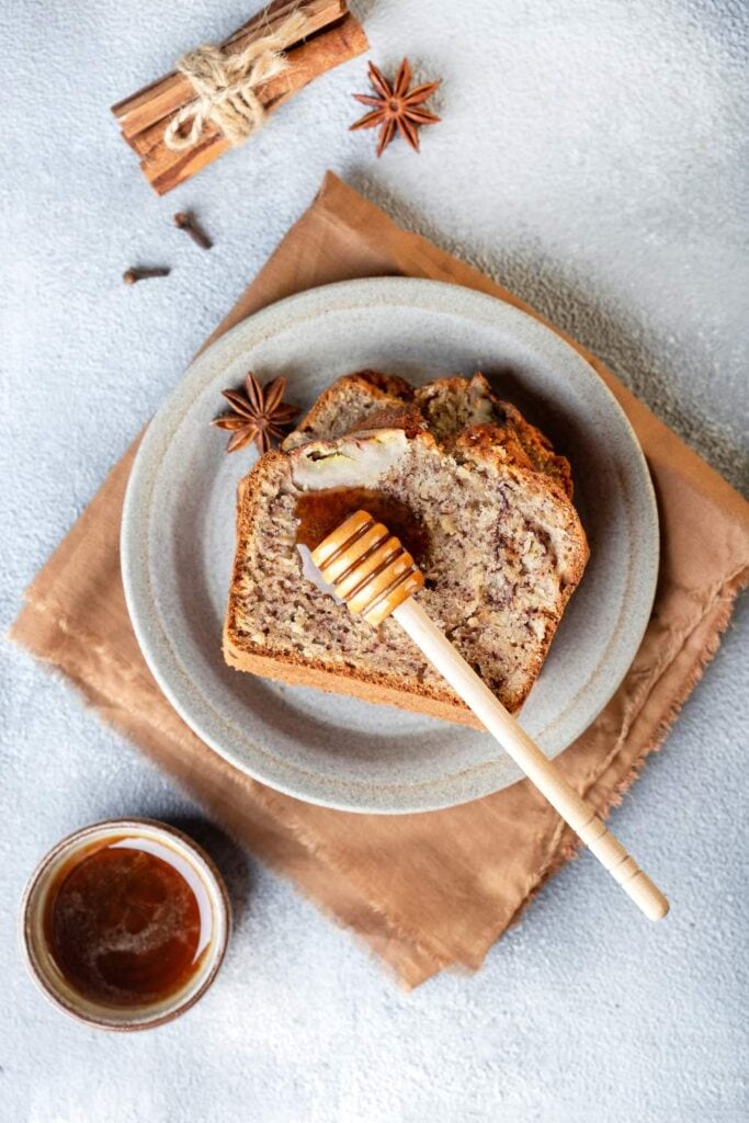 Slices of banana bread in plate drizzling with honey