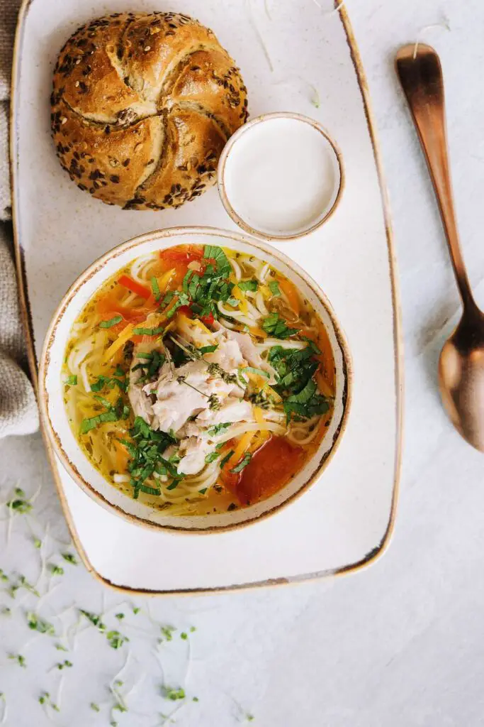 Spicy Chicken Noodle Soup in bowl with bread