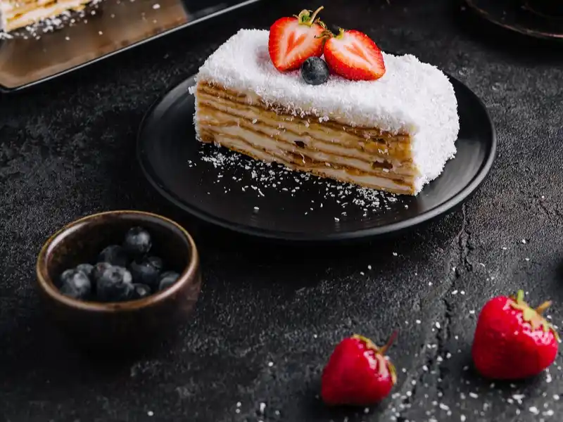 Piece of strawberry cake with frosting in plate 