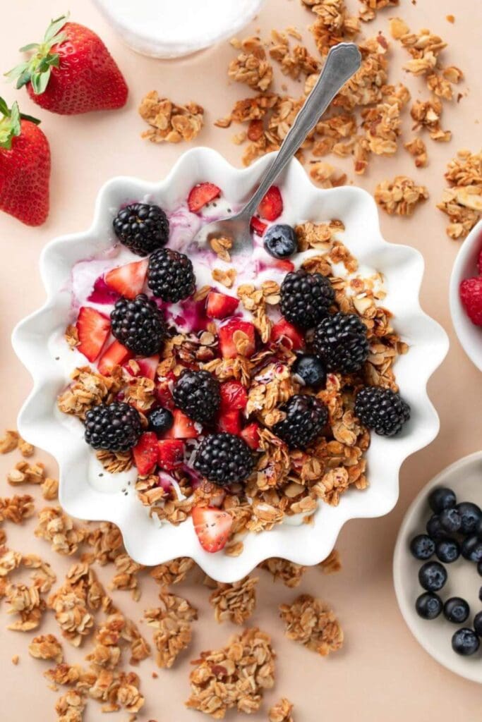 
A bowl of thick Greek yogurt topped with juicy blackberries