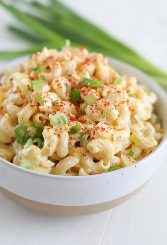 Deviled Egg Pasta Salad showing spiral pasta, sliced hard-boiled eggs, celery, and red onion