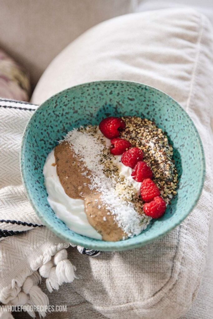 A bowl of creamy Greek yogurt topped with fresh raspberries