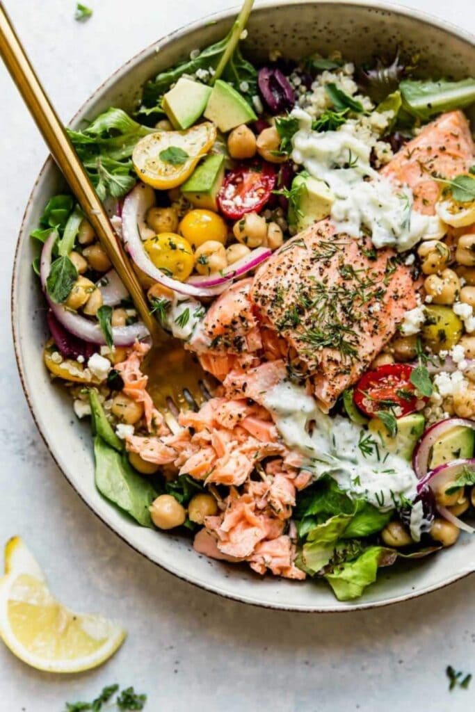  bowl featuring grilled salmon, quinoa, mixed greens,