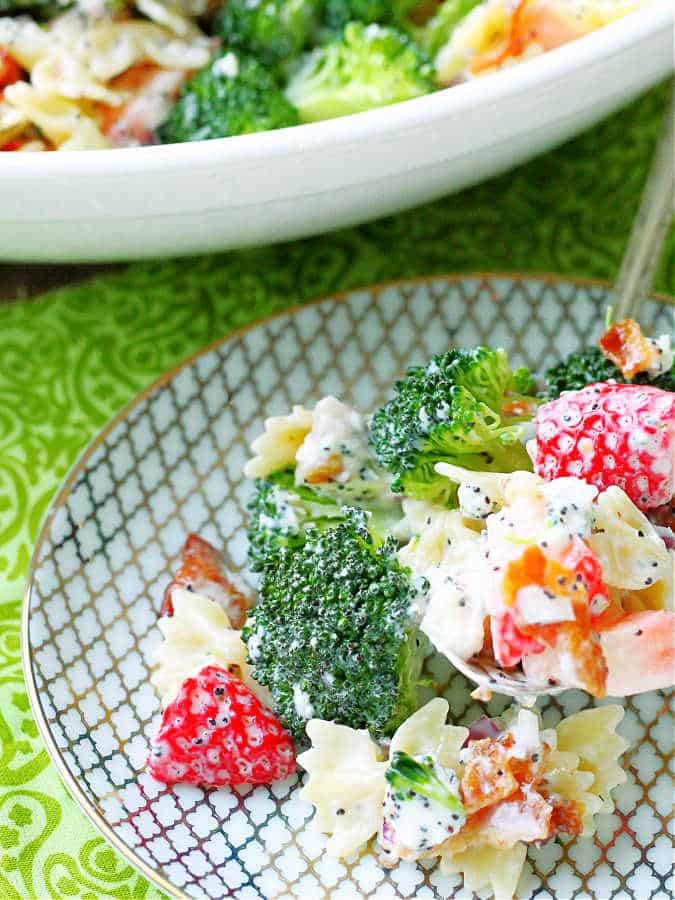 A colorful Summer Broccoli Pasta Salad in a large bowl, showcasing fusilli pasta mixed with blanched broccoli florets, and strawberry