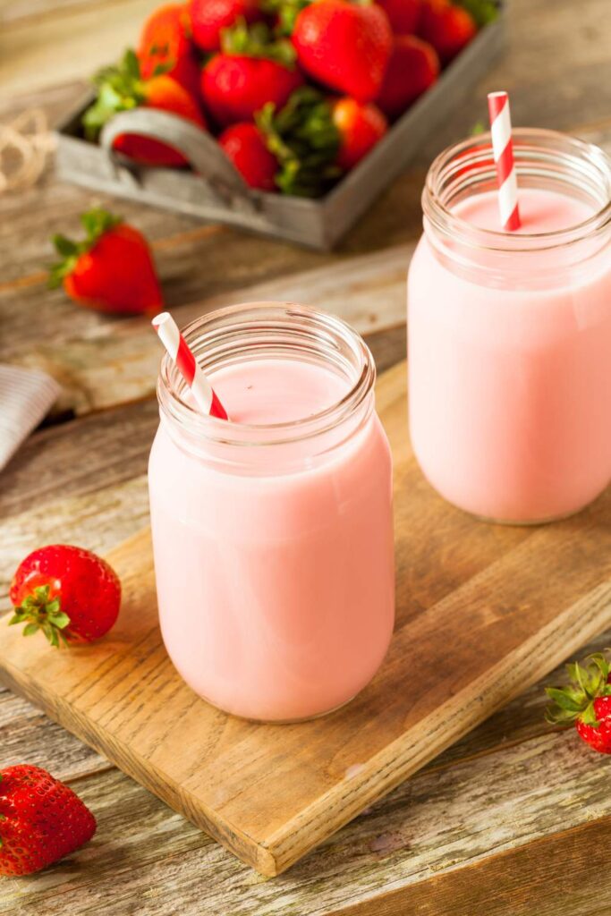 two glass of strawberry milk with drinking pipes