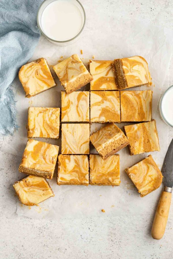 pumpkin cream cheese bars with knife and milk