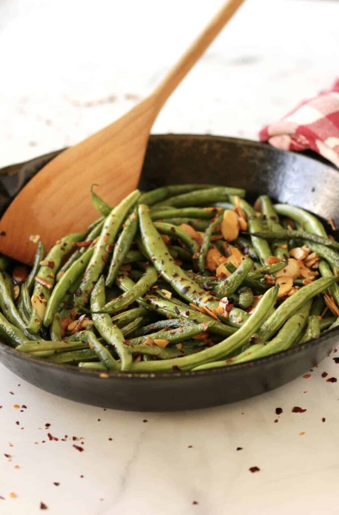 Sautéed Green Beans with Almonds with wooden spoon