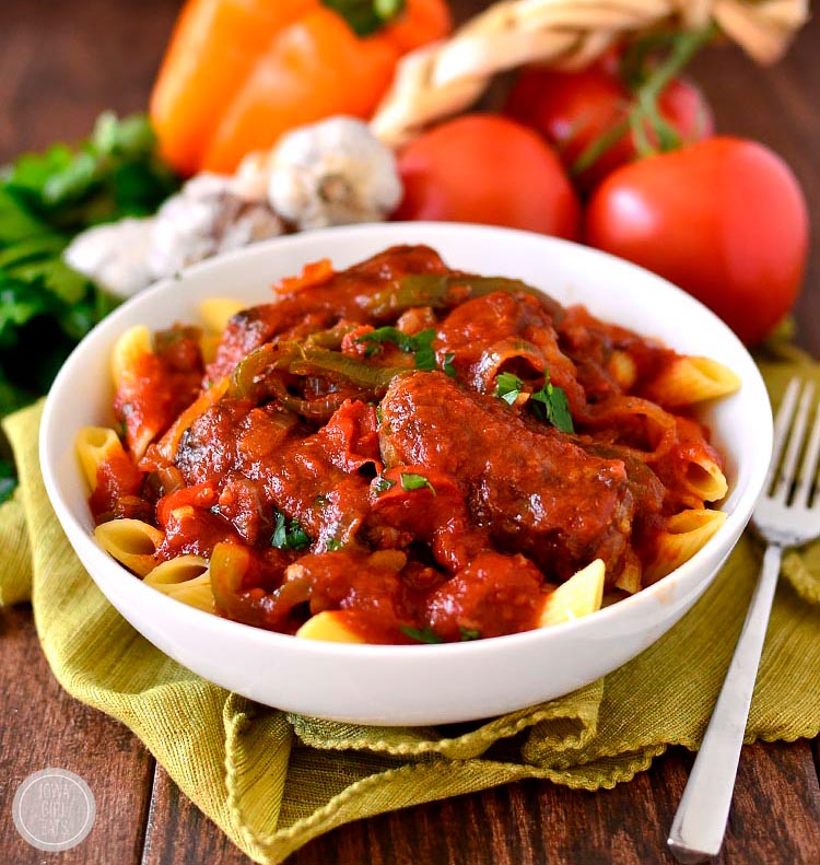 Slow Cooker Sausage and Peppers in white bowl with fork