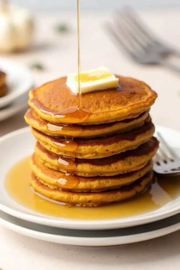 stacks of oatmeal pancakes drizzle with maple syrup