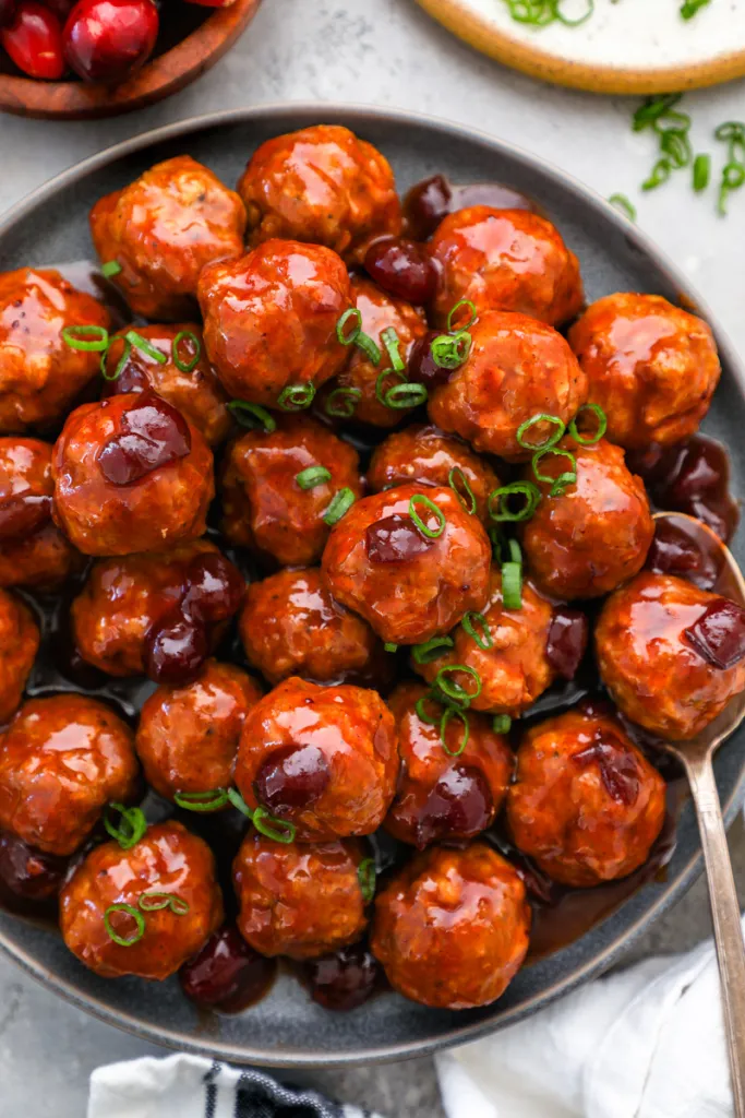 Crockpot Cranberry BBQ Meatballs in black plate with spoon