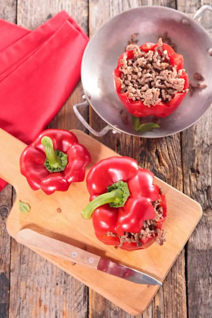 Stuffed Peppers With Cream Cheese And Ground Beef on wooden plate with knife