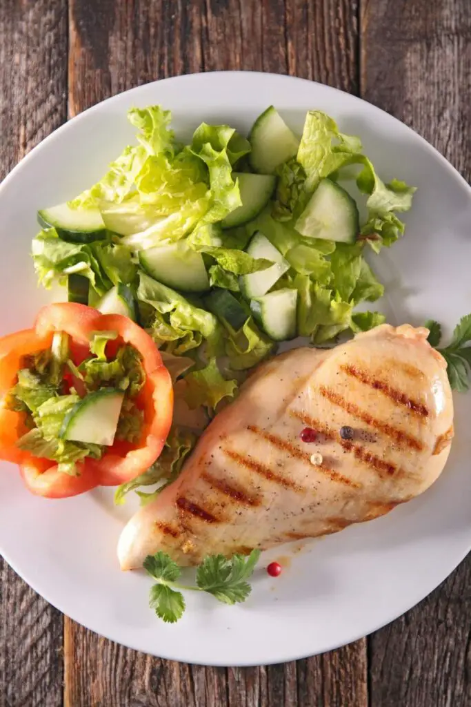 cooked chicken breast in white plate on wooden table