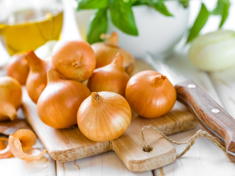 Onions with knife and wooden board