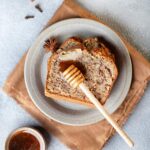 Slices of banana bread in plate drizzling with honey