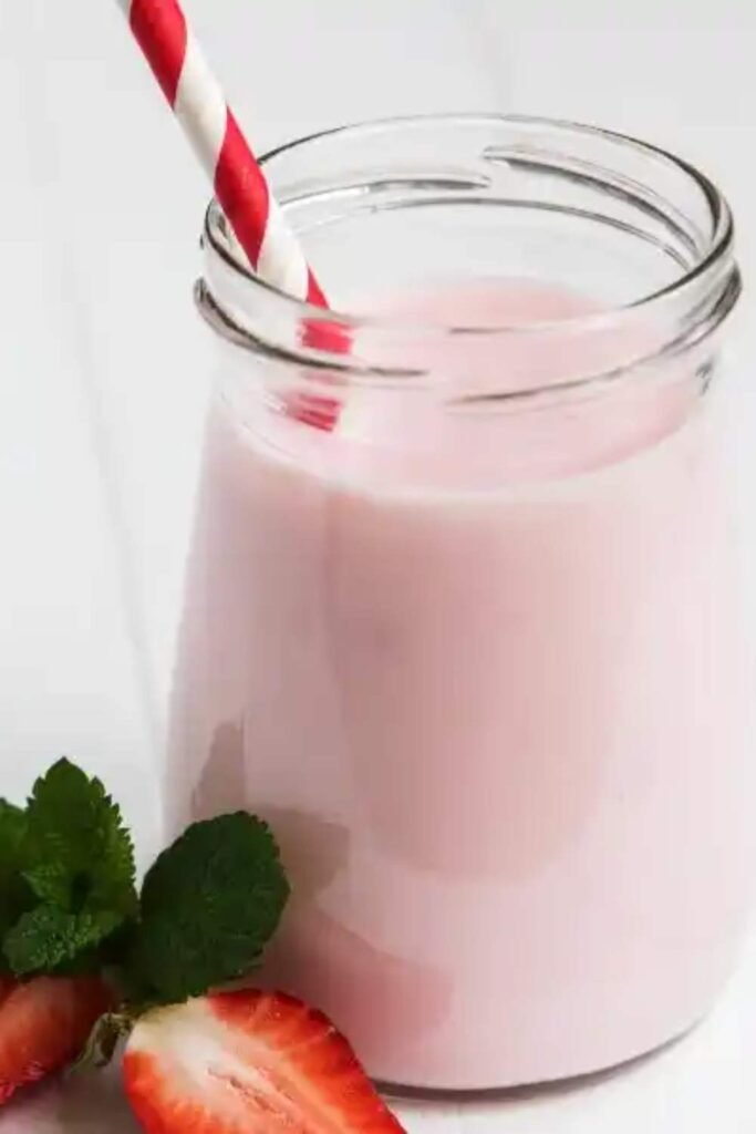 Strawberry and mint smoothie in glass with pipe