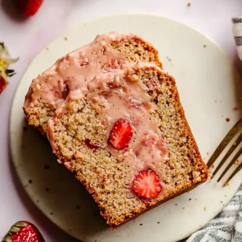 slices of Gluten Free Strawberry Bread in white plate and strawberries are placed nearby