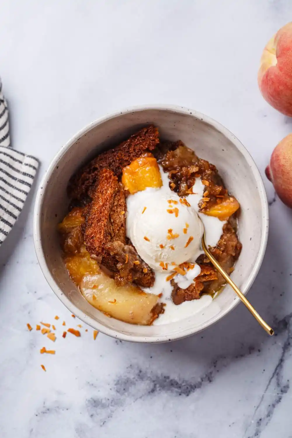 white bowl filled with a generous portion of peach cobbler