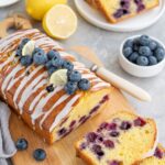 far view of lemon blueberry cakke and nearly bowl of blueberries are placed