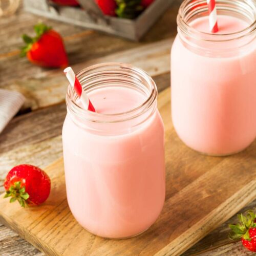 two glass of strawberry milk with drinking pipes