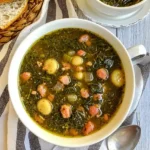 two bowls filled with turnip green soup and bread is place nearby