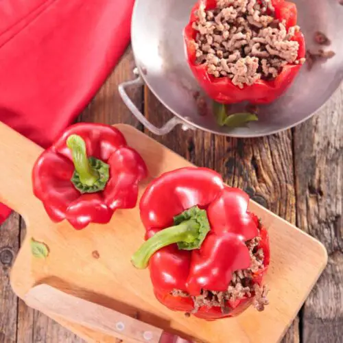 Stuffed Peppers With Cream Cheese And Ground Beef on wooden plate with knife