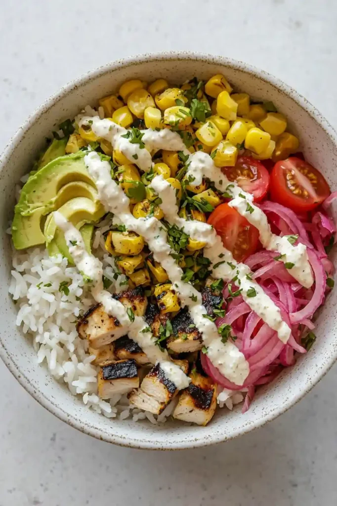 chicken rice bowl served in a white ceramic bowl sprinkled with chicken rice bowl sauce
