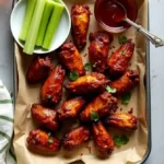 top view of wings with henessey sauce in glass bowl