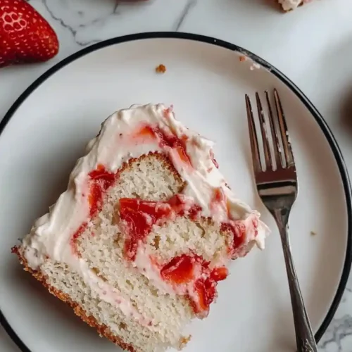 strawberry vanilla swirl cake slice in plate with fork