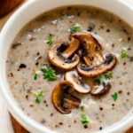 La Madeleine Mushroom Soup in white place on wooden board